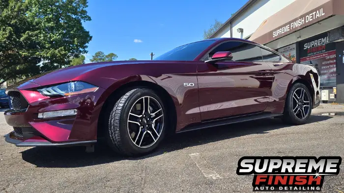 2018 Ford Mustang Detailing. Side view of a Ford Mustang showing the front wheel, door and 5.0 fender badge. Ford Mustang detailing routine with Supreme Gold VIP.
