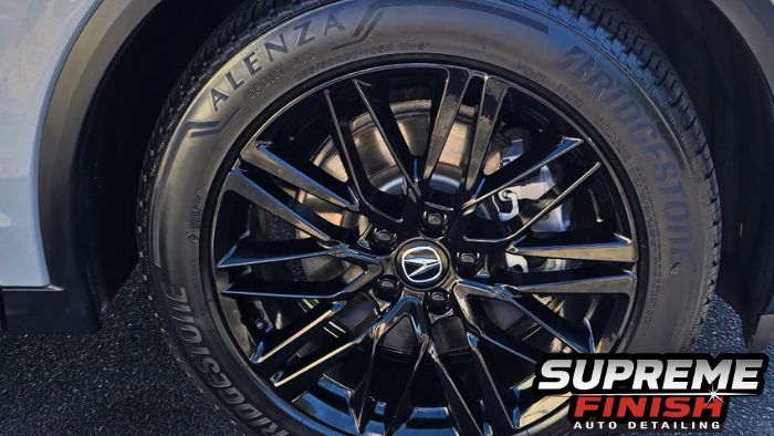 Close-up of an Acura MDX gloss-black wheel and tire sidewall finished with ceramic tire shine