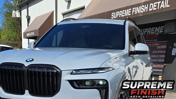 BMW X7 Ceramic coating front view showing reflective paint, split headlights, and black kidney grille.