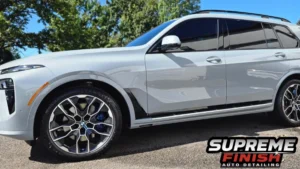 BMW X7 window tint showing dark SunTek tinted windows and black exterior trim in a driver-side view.